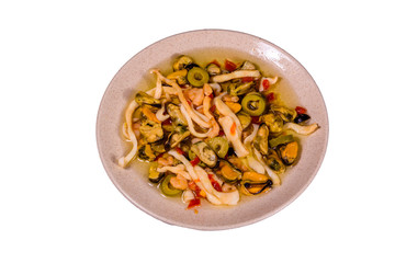 Ceramic plate with the different sea food and olives isolated on white background