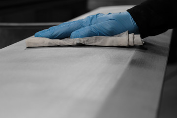 man cleaning a metal panel with a cloth preparing for spraying