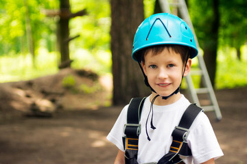 Fototapeta na wymiar Five year boy on rope-way in forest