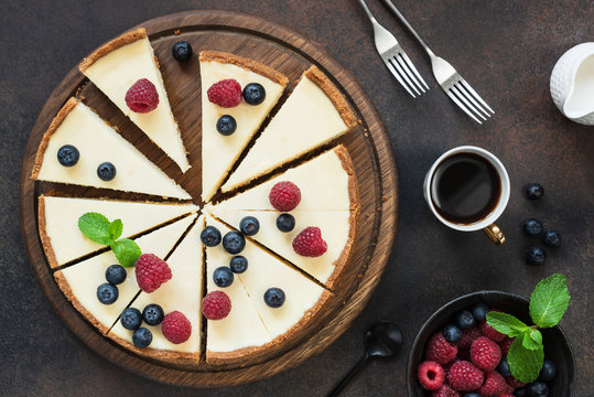 Top view of cheesecake with summer berries on dark background. Horizontal composition