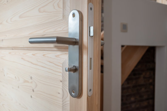 Poign&eacute;e m&eacute;tallique sur une porte en bois