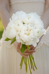 Bride holding wedding bouquet. White peony flowers. Classical elegance. 