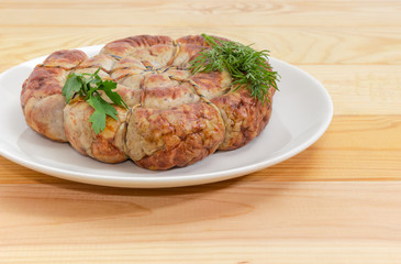 Homemade sausage baked in spiral on dish closeup