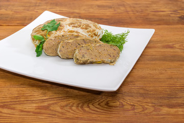 Baked pork liver pate on dish on rustic table closeup
