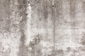 Old concrete wall with chips, cracks and holes.