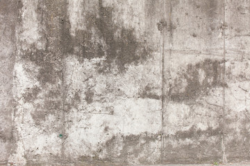 Old concrete wall with divorces, chips, cracks and holes.