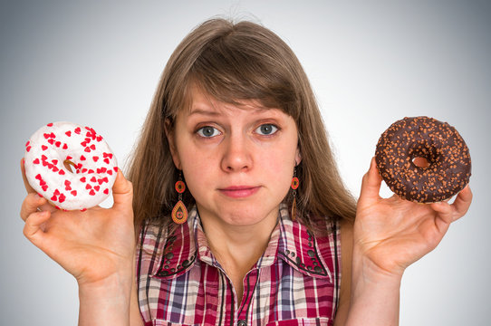 Attractive woman is choosing between two donuts