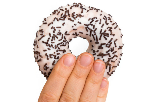 Female hand is holding donut with sprinkles