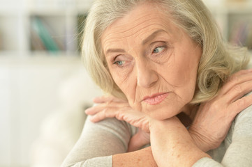  sad  senior woman sitting at table