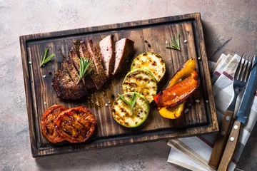 Plexiglas foto achterwand Barbecue dish. Beef steak and grilled vegetables top view. © nadianb