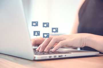 Businesswoman hands using laptop with icon social media and social network, Marketing concept.