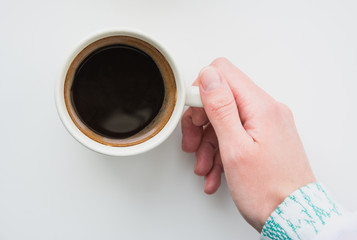 Cup of coffee in the woman's hand, view from above