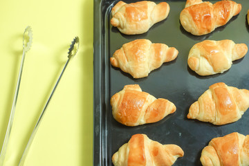 Fresh bread. Image to have bread with a tong. Image of the bakery or handmade bread. 焼きたてパン　トングでパンをとるイメージ。パン屋や手作りパンのイメージ　黄色背景