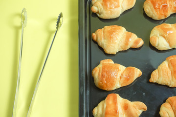 Fresh bread. Image to have bread with a tong. Image of the bakery or handmade bread. 焼きたてパン　トングでパンをとるイメージ。パン屋や手作りパンのイメージ　黄色背景