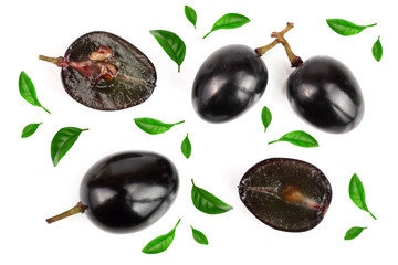 Dark grapes decorated with green leaves isolated on white background, top view. Flat lay