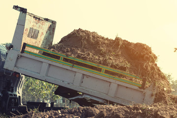 dump truck preparing ground for landscape improvement at property project;Dump truck dumping and...
