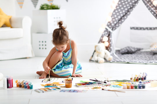 cute child girl paints at home