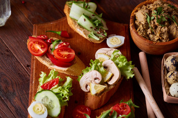 Breakfast sandwich with homemade paste, vegetables and fresh greens, shallow depth of field