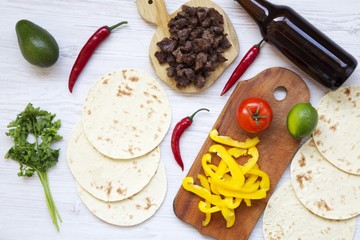 Tortillas on white wooden table. Ingredients for cooking tacos. Top view. From above. Flat lay.