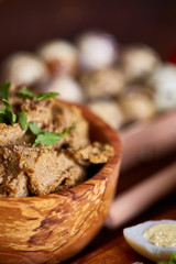 Paste from chicken liver with vegetables and quail eggs, shallow depth of field, close-up.
