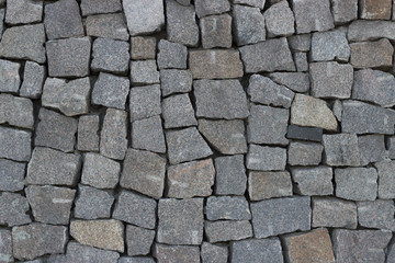 A wall of gray cobblestones of different shapes, texture, background