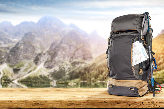 backpack on desk and mountains landscape 