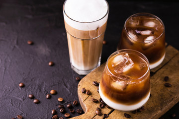 Iced coffee in glasses with milk. Black background