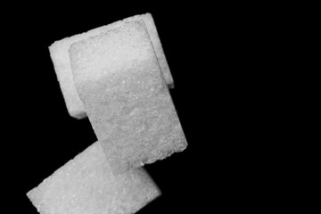 Background of cubes of sugar on a black background macro