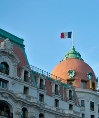 French flag at the top of a historic building with red tiles