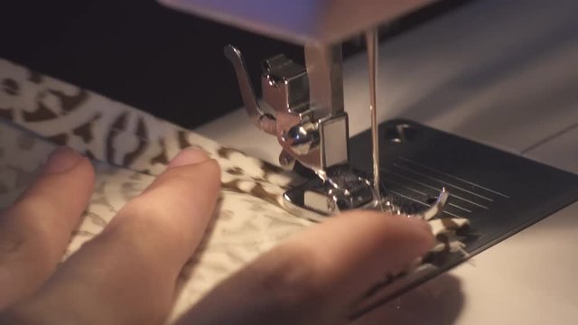 Woman hands working with domestic sewing machine.