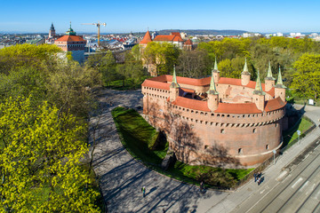 Barbican (Barbakan) in Cracow, Poland. The best preserved medieval barbican in Europe and Planty park surrounding the old city. Aerial view - obrazy, fototapety, plakaty