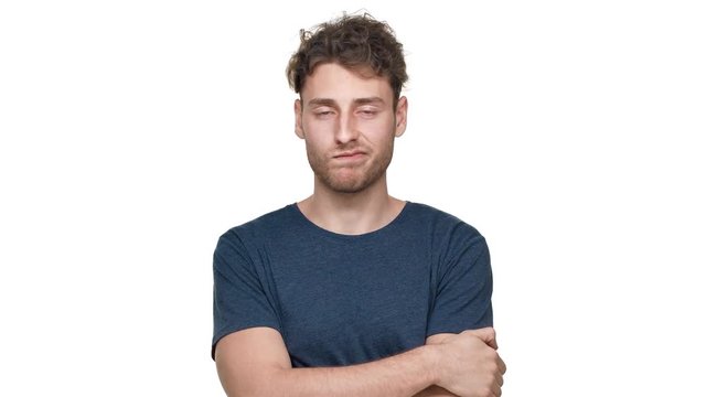 Portrait of determined strict guy in t-shirt posing with arms crossed and shaking head in denial, isolated over white background. Concept of emotions