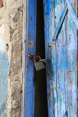 Rusted lock on a weathered blue door.