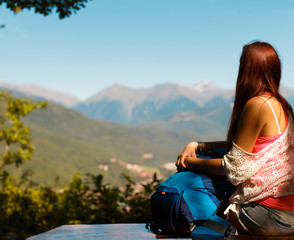 Long-haired woman against backdrop of mountain landscape
