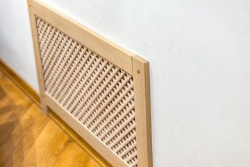 closeup of wooden cover radiator on the wall.