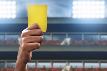 Soccer referee hand holding yellow card