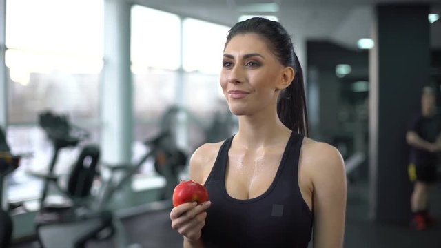 Sport female eating apple after workout, balanced nutrition, active lifestyle