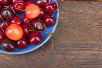Various summer Fresh Cherry in a bowl on rustic wooden table. Antioxidants, detox diet, organic fruits. Berries