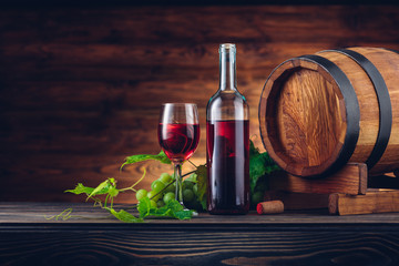 Wine bottle and glasses with wooden barrel on the table