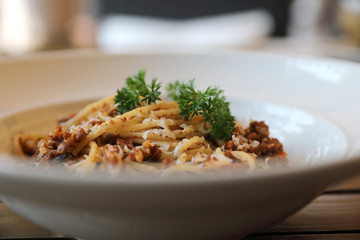 spaghetti Bolognese with minced beef and tomato sauce garnished with parmesan cheese and basil , Italian food
