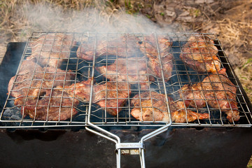 Juicy pork steak cooking on an open flame grill.