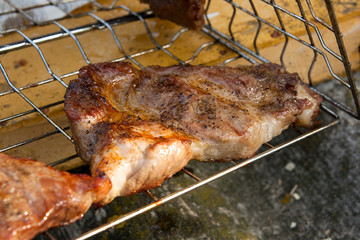 Close up view of juicy pork steak cooked on an open flame grill..