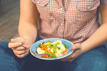 Girl with a plate of vegetables in hands. Healthy eating concept. Proper nutrition. Vegetarian food. Vegans food. Toned image.