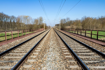 Fototapeta na wymiar Symmetry railway in spring countryside under blue sky