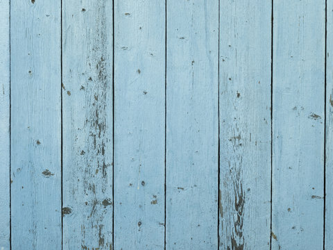 Barn wood wall with distressed, peeling blue paint