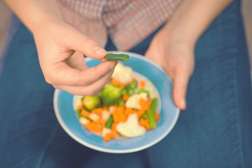 Girl with a plate of vegetables in hands. Healthy eating concept. Proper nutrition. Vegetarian food. Vegans food. Toned image.