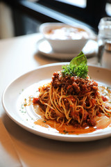 spaghetti Bolognese with minced beef and tomato sauce garnished with parmesan cheese and basil , Italian food