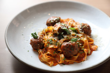 Spaghetti pasta with beef meatballs and tomato sauce on wood background . italian food
