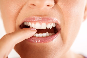 Woman biting her finger with teeth