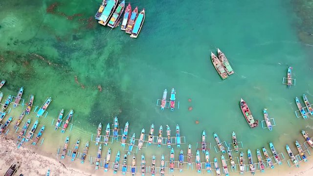 Beautiful aerial shot of traditional fisherman boats anchoring in a row at ujung Genteng beach, Sukabumi, West Java, Indonesia